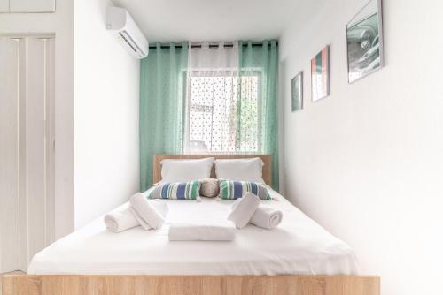 a bedroom with a bed with white sheets and pillows at Renovated Studio near Downtown in Heraklio
