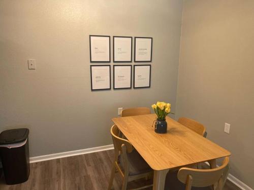 a table with chairs and a vase of flowers on it at The Ingrid Apt #8 - Fresh and Simple 2bd with WiFi in Hamilton