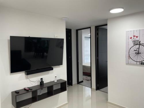 a living room with a flat screen tv on a wall at Ubicación ideal, Apartamento frente al CC Cacique in Bucaramanga