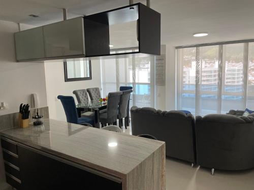 a kitchen and living room with a couch and chairs at Ubicación ideal, Apartamento frente al CC Cacique in Bucaramanga