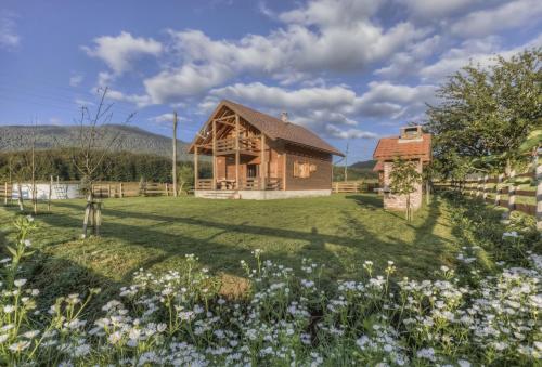 a house in the middle of a field with flowers at Chalet Sanjam Liku in Bužim