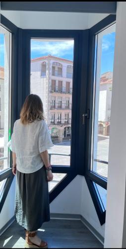 a woman standing in front of a window at Plasencia Plaza Mayor Luxury in Plasencia