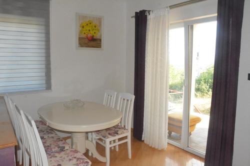a dining room with a table and chairs and a balcony at Gazdinstvo Tadić in Nikšić