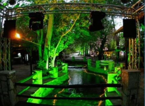 a green garden with a pond and a tree at Massabki Hotel in Chtaura