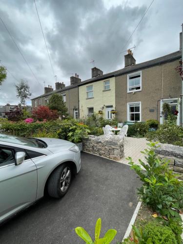 um carro estacionado em frente a uma casa em The Stopping Point- Exceptional Cumbrian Cottage em Flookburgh