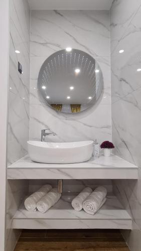 a white bathroom with a sink and a mirror at Gold Luxury Room in Split
