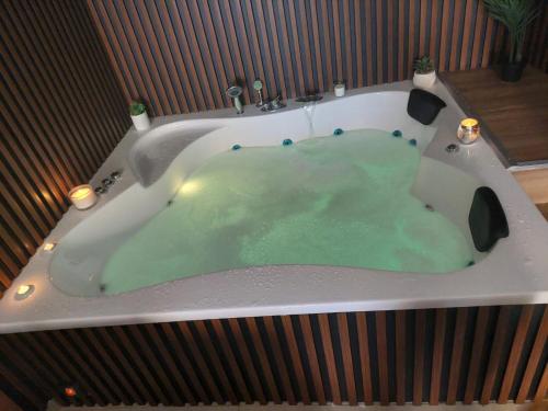 a bath tub with green water in it at קסם הכפר in Ein Kinya
