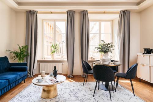 a living room with a blue couch and a table at Bogoria Residence - LoftAffair Collection in Kraków