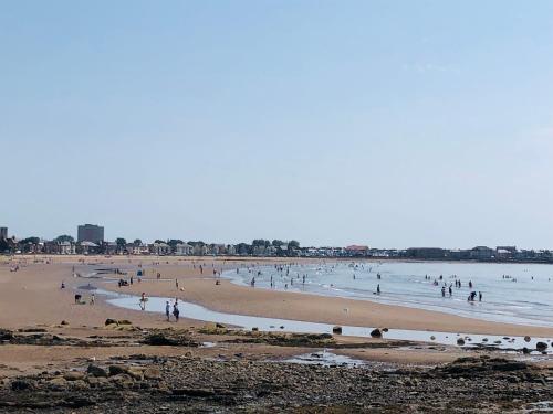 a group of people on a beach in the water at South Beach Apartment in Ardrossan