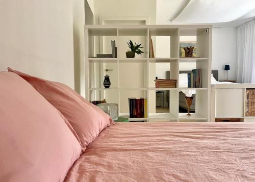 - une chambre avec un lit rose et des étagères blanches dans l'établissement atelier2, à Hamont