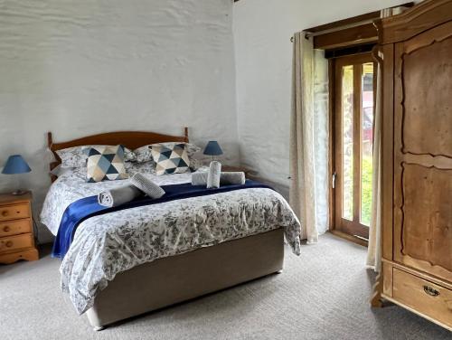 a bedroom with a bed and a wooden dresser at Cedar Lodge in Looe