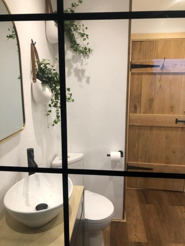 a bathroom with a toilet and a sink at Coorie View in Kilmore