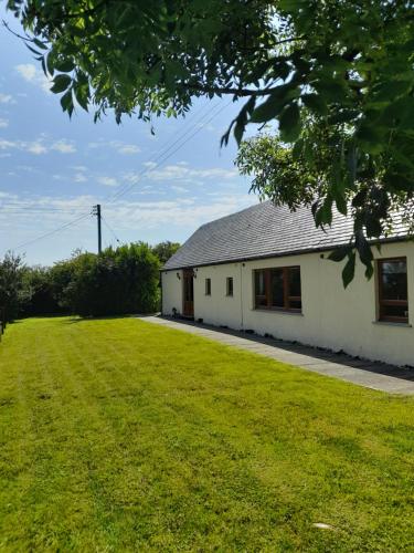 a white building with a large grass yard at Coorie View in Kilmore