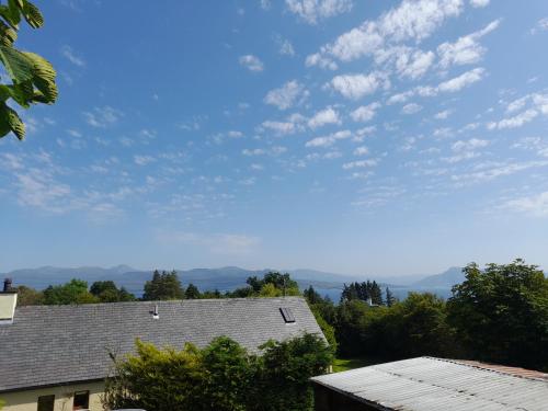 a blue sky with clouds over roofs of houses at Coorie View in Kilmore