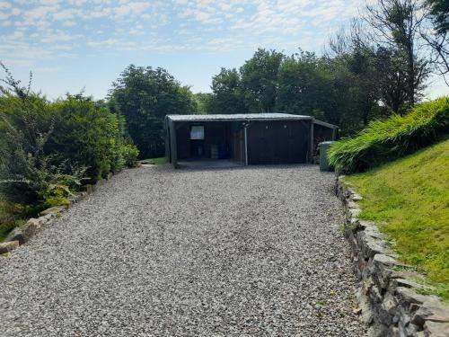 a gravel driveway in front of a shed at Coorie View in Kilmore