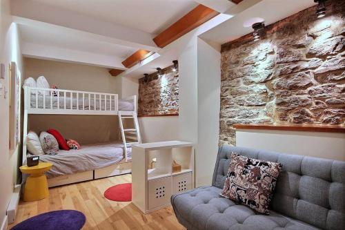 魁北克市的住宿－GENERATIONS QUEBEC OLD CITY/ Parking/ Family，客房设有双层床和岩石墙。