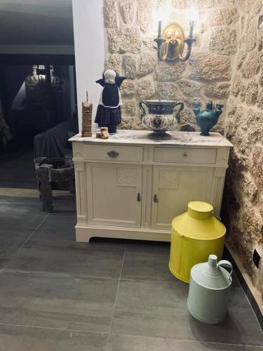 a room with a white cabinet and a yellow stool at Casa da Avó Maria in Monsanto