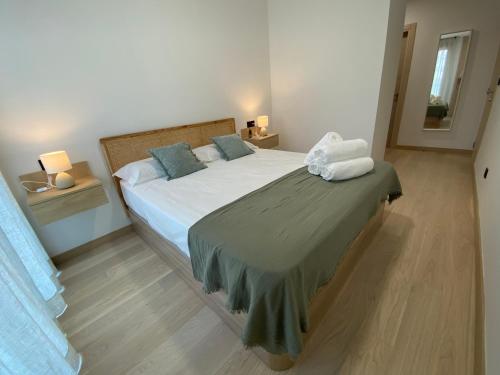 1 dormitorio con 1 cama blanca grande con almohadas azules en Move in Miragaia, en Vigo