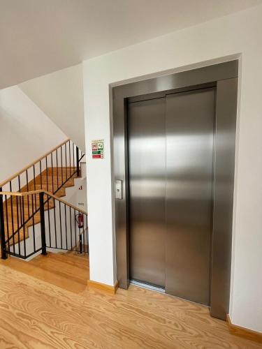 a metal elevator in a room with stairs at Lux Life Properties in Nazaré