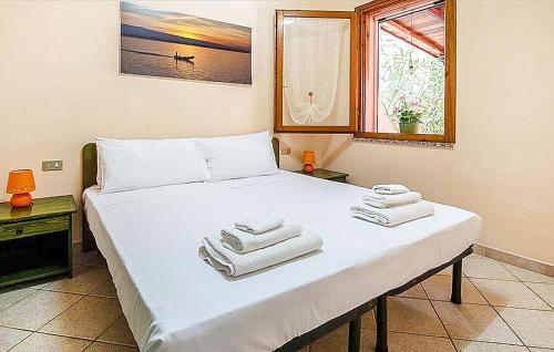 a bedroom with a large white bed with towels on it at Amazing Home In Torre Dei Corsari With Kitchen in Torre Dei Corsari