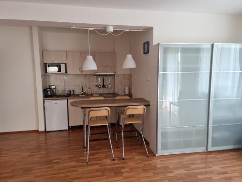 a kitchen with a table and two stools in it at Panorama View Apartment in Hajdúszoboszló