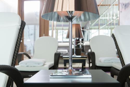 a table with a lamp on a table with chairs at Hotel Zürserhof in Zürs am Arlberg