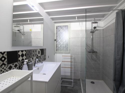 ein weißes Badezimmer mit Dusche und Waschbecken in der Unterkunft Bel Appartement T2 Duplex en Hyper Centre, 3*, Parking, 4 Pers., Proche Thermes et Commerces - FR-1-608-233 in La Bourboule
