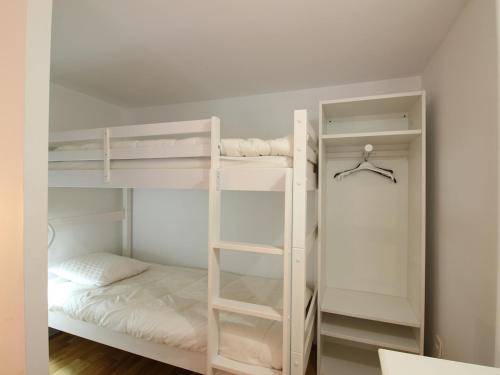 ein weißes Etagenbett in einem kleinen Zimmer in der Unterkunft Bel Appartement T2 Duplex en Hyper Centre, 3*, Parking, 4 Pers., Proche Thermes et Commerces - FR-1-608-233 in La Bourboule