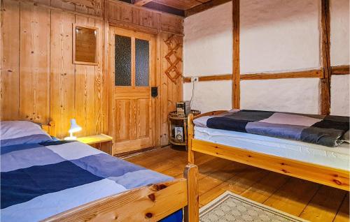 um quarto com 2 camas num chalé de madeira em Ferienhaus Lausche Haeusl em Waltersdorf