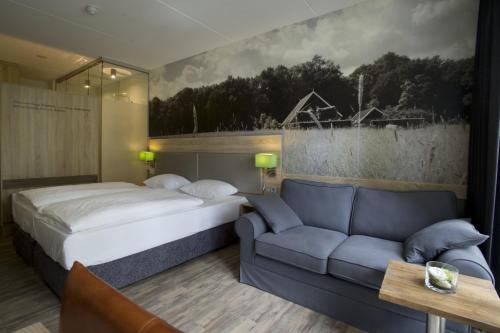 a bedroom with a bed and a couch at Hotel Erve Hulsbeek in Oldenzaal