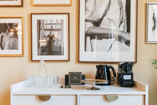 a white cabinet with some pictures on the wall at Bogoria Residence - LoftAffair Collection in Kraków