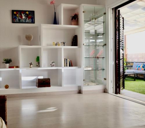 una sala de estar con estanterías blancas y una puerta corredera de cristal en La Marieta, en Callao Salvaje