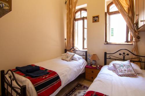 a bedroom with two beds and two windows at BREAD HOUSE in Bethlehem