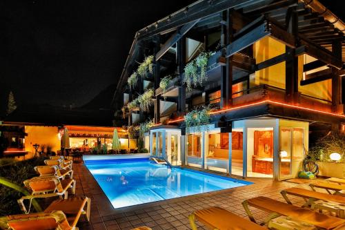 a swimming pool in front of a building at night at Hotel Pfeifer in Gaschurn