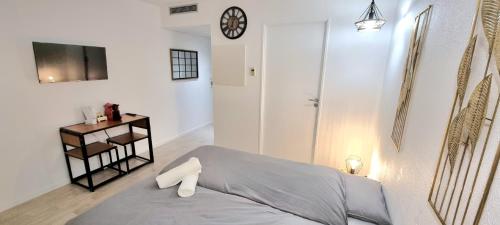 a bedroom with a bed and a clock on the wall at STUDIO COSY - VUE MONTAGNE - CLIM - GARE in Lourdes