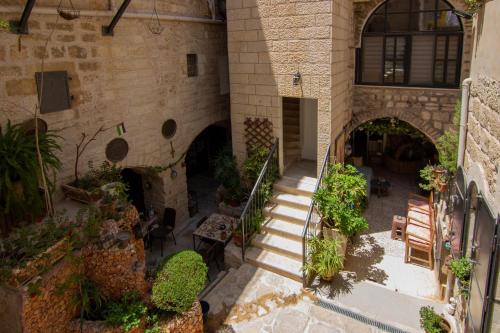 einen Innenhof eines Gebäudes mit Treppen und Pflanzen in der Unterkunft BREAD HOUSE in Bethlehem