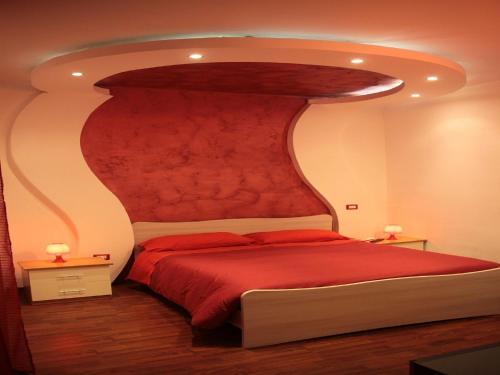 una camera con un grande letto con testiera rossa di B&B Cosenza a Cosenza