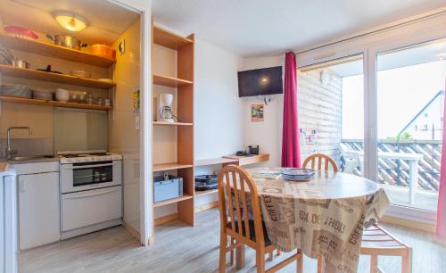 een keuken en eetkamer met een tafel en stoelen bij Les Aliziers in Super Besse