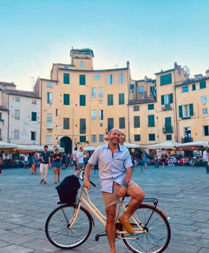 a man is sitting on a bike in a city at BnB Villa Melany vicino Centro in Lucca