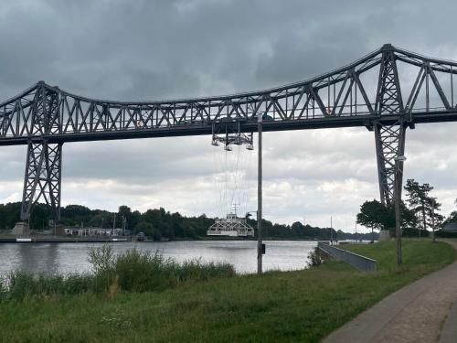 a bridge over a river with a boat on the water at Haus Wald und Wiese Wohnung Wald in Ehndorf