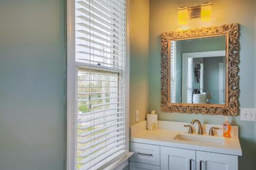 a bathroom with a sink and a mirror and a window at Lighthouse By The Sea in St. George Island