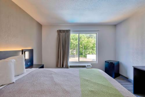 a bedroom with a bed and a large window at Motel 6 Virginia Beach in Virginia Beach