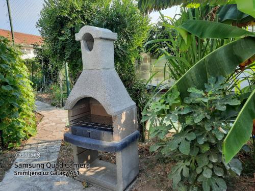 um forno de pedra no meio de um jardim em El Sol Apartmani em Bar