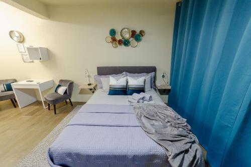 Schlafzimmer mit einem Bett mit blauen Vorhängen in der Unterkunft LittleLux Living in George Hill