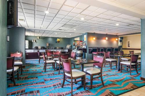 a restaurant with tables and chairs on a colorful carpet at Best Western Dutch Valley Inn in New Philadelphia
