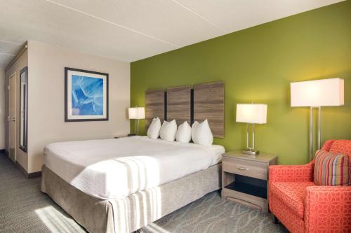 um quarto com uma cama grande e uma cadeira vermelha em Best Western Dutch Valley Inn em New Philadelphia