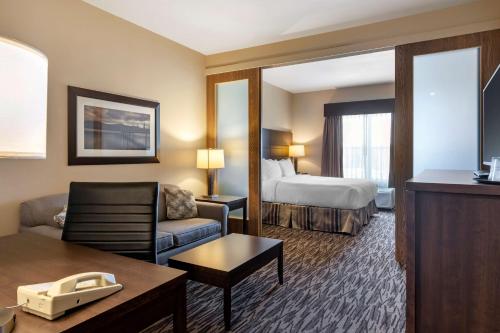 a hotel room with a bed and a living room at Best Western Plus Bridgewater Hotel & Convention Centre in Bridgewater
