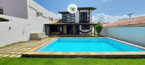 a swimming pool in front of a house at COSTE0101 - Casa com piscina em Stella Maris in Salvador