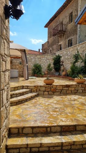 a stone courtyard with stairs and a stone wall at Villa Porta Qeparo in Qeparo