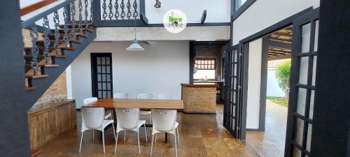 a dining room with a table and white chairs at COSTE0101 - Casa com piscina em Stella Maris in Salvador